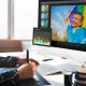 A person using a graphic tablet to edit photos on a computer screen displaying a histogram and colorful images.